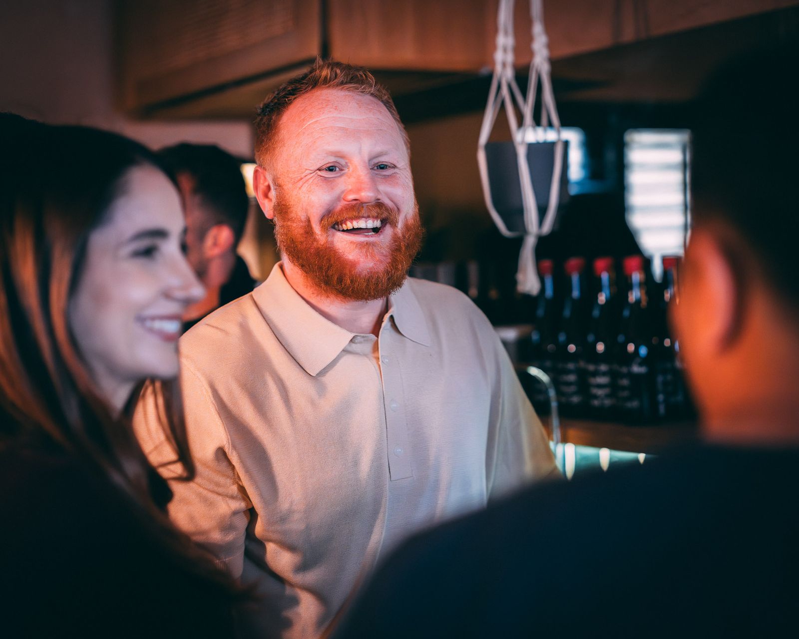 Guests laughing together at an evening drinks event