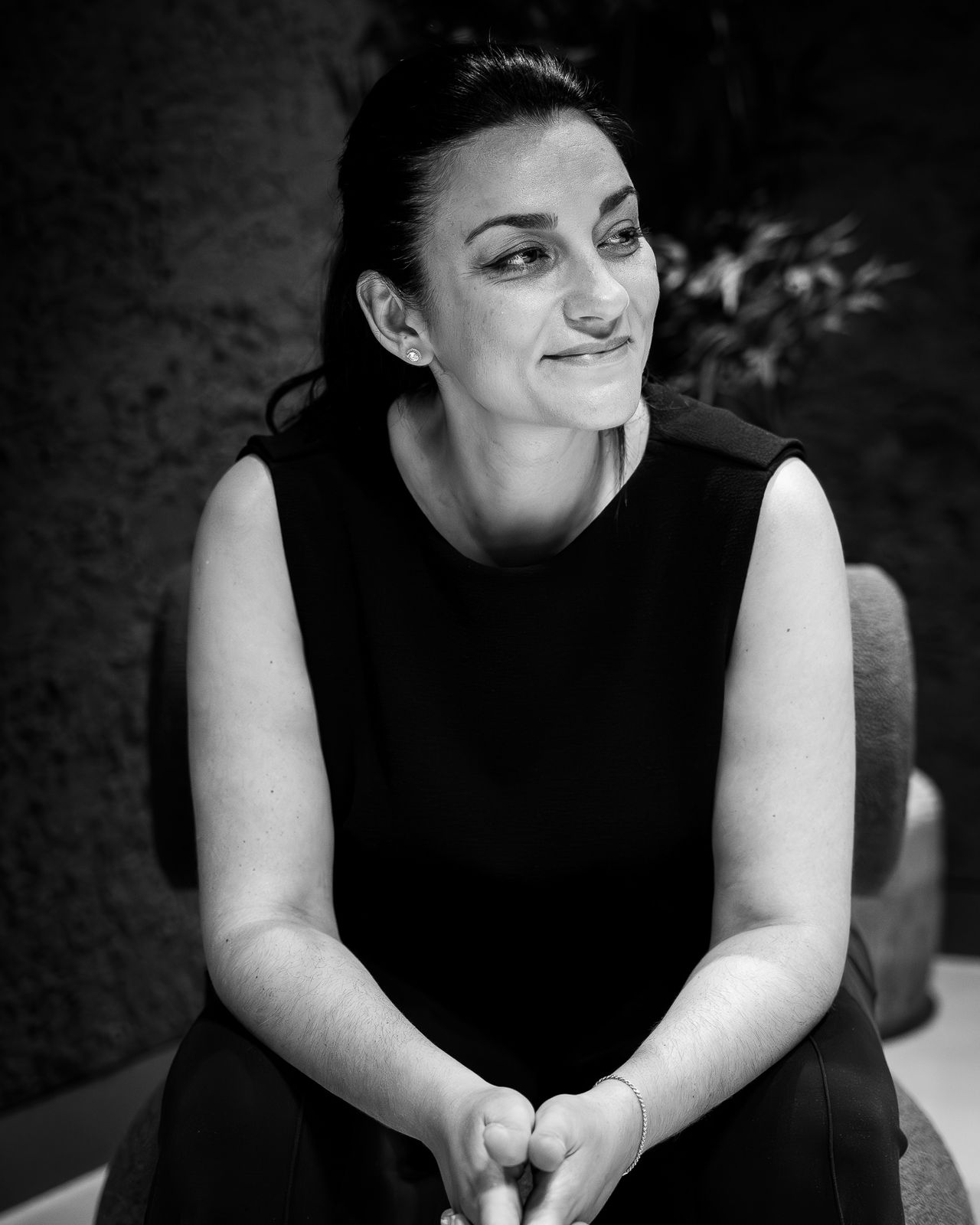Black-and-white portrait of a woman seated in a dark interior