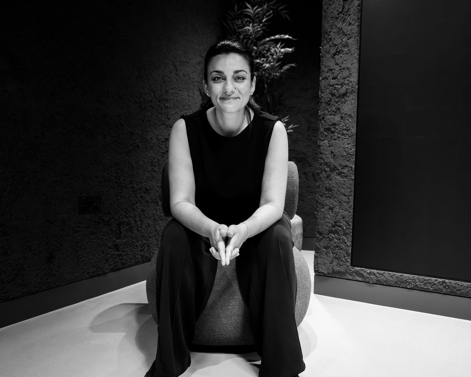 Black-and-white portrait of a woman seated in a minimal interior