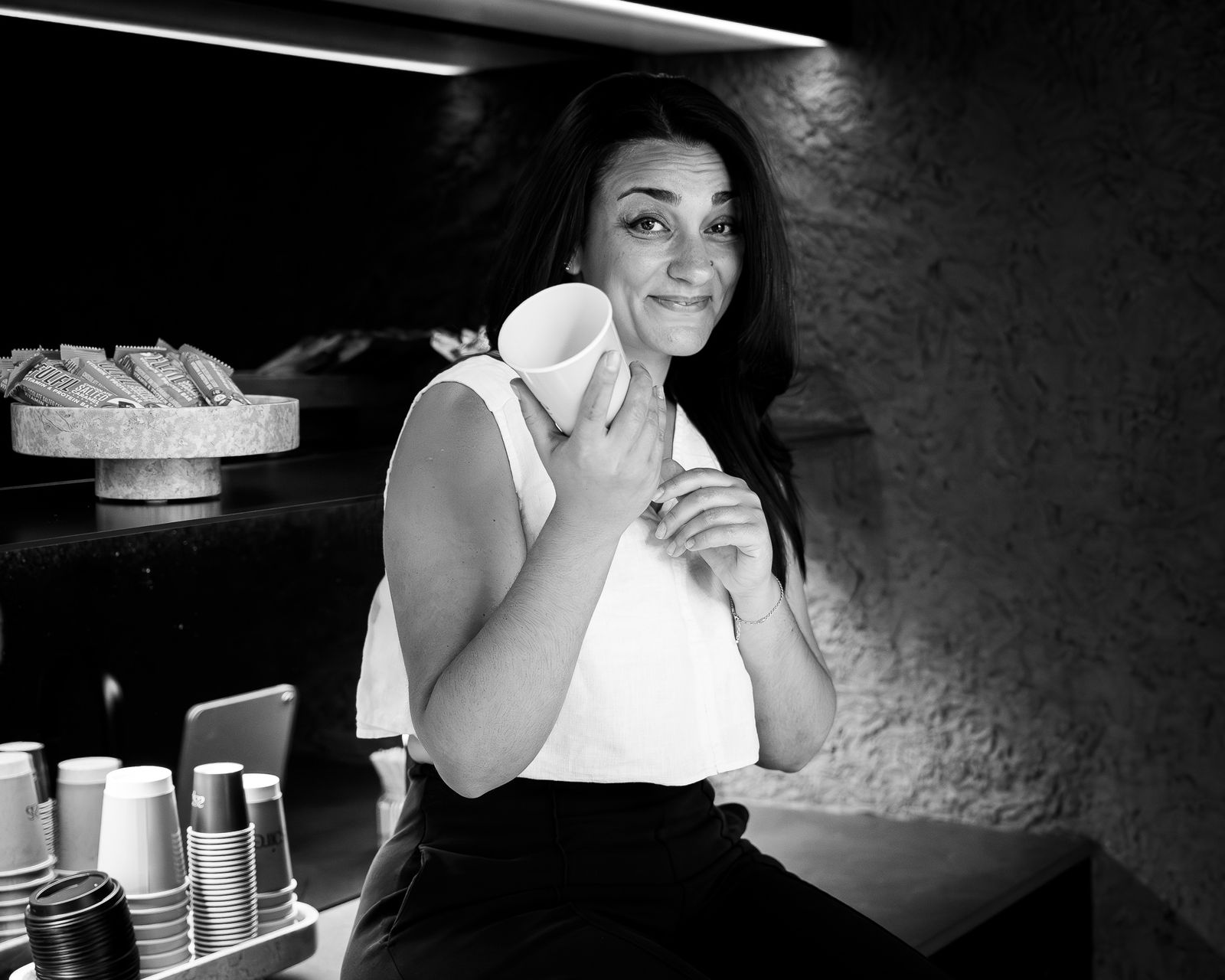 Black-and-white portrait of a woman holding a coffee cup